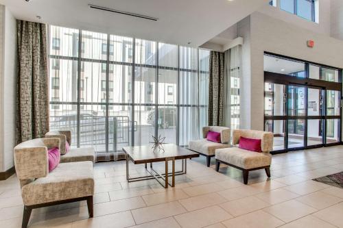 a lobby with chairs and a table with pink pillows at Hilton Garden Inn Dallas-Central Expy/North Park Area, Tx in Dallas