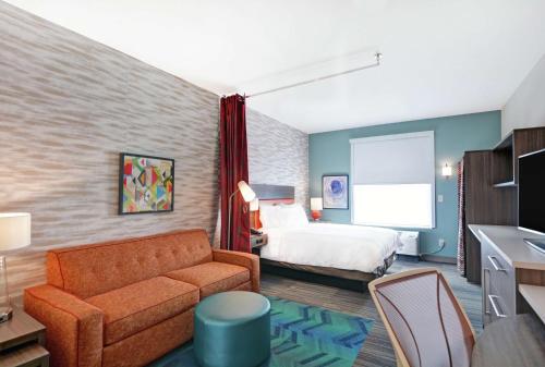 une chambre d'hôtel avec un lit et un canapé dans l'établissement Home2 Suites By Hilton Grand Junction Northwest, à Grand Junction