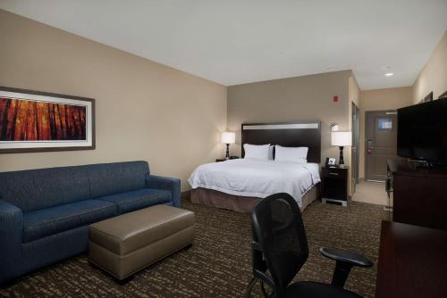 pokój hotelowy z łóżkiem i kanapą w obiekcie Hampton Inn & Suites Portland/Vancouver w mieście Vancouver