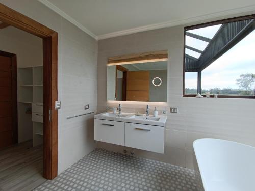 uma casa de banho com um lavatório e um espelho em Los laureles em Frutillar