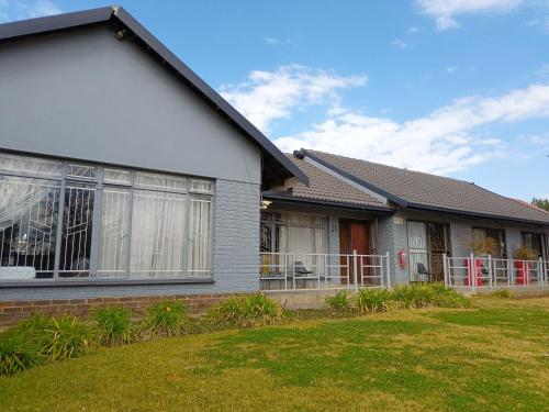 a house with a fence in front of it at 21 On Coetzee Guest House in Bloemfontein