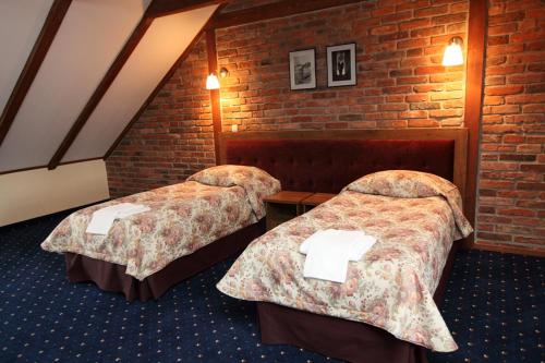 a hotel room with two beds and a brick wall at U Pietrzaków in Zielonka