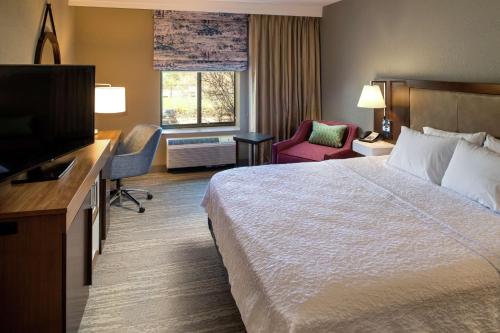 a hotel room with a bed and a flat screen tv at Hampton Inn & Suites Binghamton/Vestal in Vestal