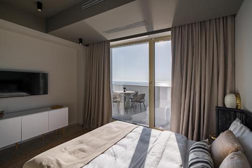 a bedroom with a bed and a view of the ocean at Rezident Tomis Marina in Constanţa