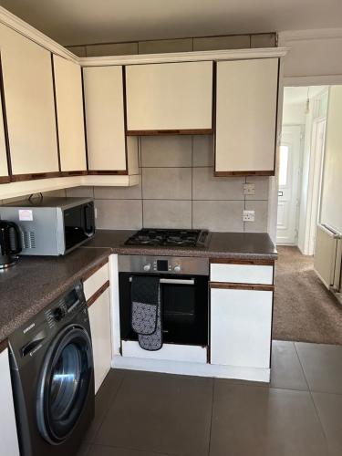 a kitchen with a washer and a stove top oven at Spacious Comfortable 4 Bedroom House in Aylesbury