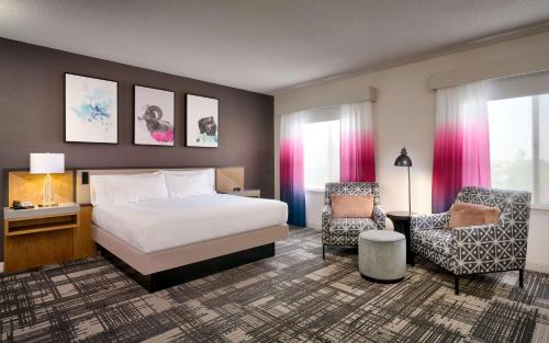 une chambre d'hôtel avec un lit et une chaise dans l'établissement Hilton Garden Inn Bozeman, à Bozeman