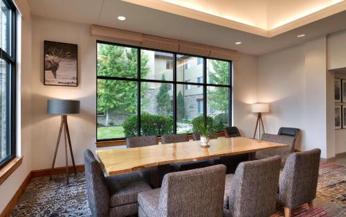 a dining room with a wooden table and chairs at Hilton Garden Inn Bozeman in Bozeman