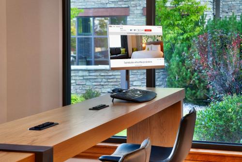 a room with a desk with chairs and a window at Hilton Garden Inn Bozeman in Bozeman