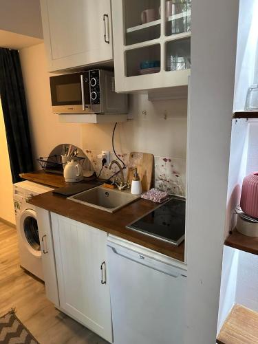 una pequeña cocina con armarios blancos y fregadero en City Centre Apartment Wielopole en Cracovia