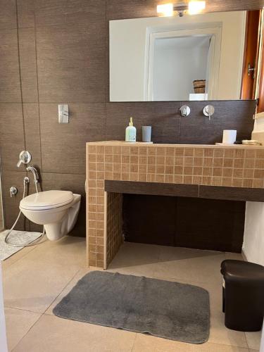 a bathroom with a sink and a toilet and a mirror at Villa Zagara in Marsala