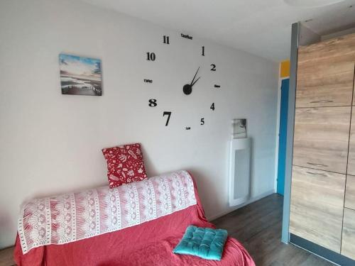 um quarto com um sofá e um relógio na parede em studio avec vue sur océan em La Pironnière