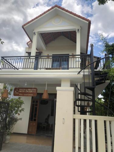a house with a balcony on top of it at Xuka Homestay in Hue