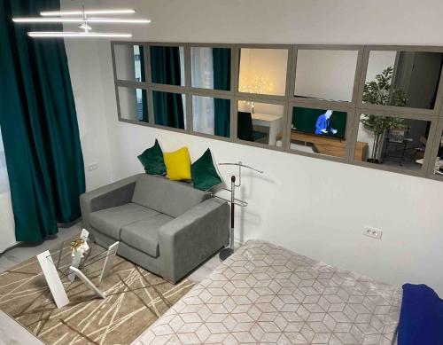 a living room with a couch and a bed and a mirror at Stylish Studio Near Orhideea Towers W Free Wifi in Bucharest