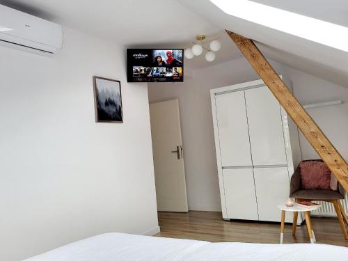 1 dormitorio con armario blanco y TV en la pared en APART KARKONOSZE - Klimatyzowany Apartament Charlotte Karpacz na deptaku z parkingiem w cenie, en Karpacz