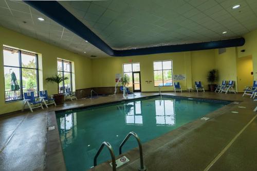 a large swimming pool in a gym with blue chairs at Embassy Suites by Hilton Minneapolis North in Brooklyn Center