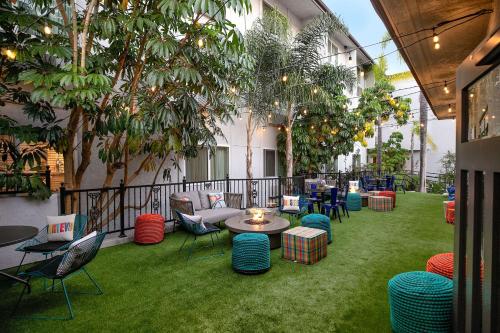 un patio con mesas, sillas y árboles en The Wayfarer San Luis Obispo, Tapestry Collection by Hilton, en San Luis Obispo