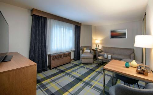 a hotel room with a living area with a couch and chair at The Wayfarer San Luis Obispo, Tapestry Collection by Hilton in San Luis Obispo