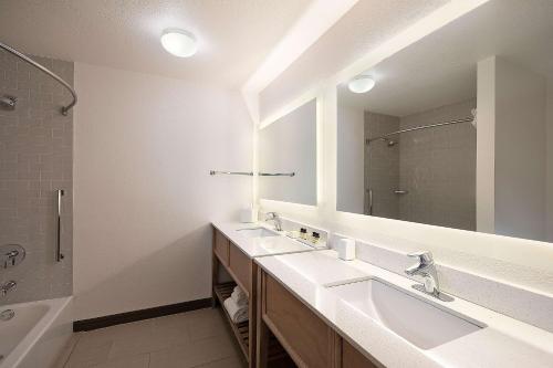 a bathroom with two sinks and a large mirror at The Wayfarer San Luis Obispo, Tapestry Collection by Hilton in San Luis Obispo