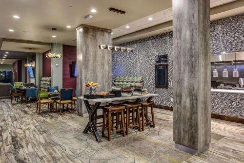 a lobby with a table and chairs and a restaurant at Hilton Garden Inn Topeka in Topeka