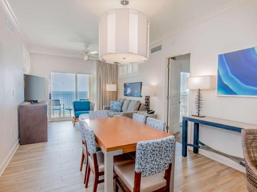 a dining room and living room with a table and chairs at Hilton Pensacola Beach in Pensacola Beach