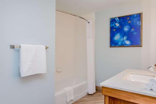 a white bathroom with a shower and a sink at Hilton Pensacola Beach in Pensacola Beach