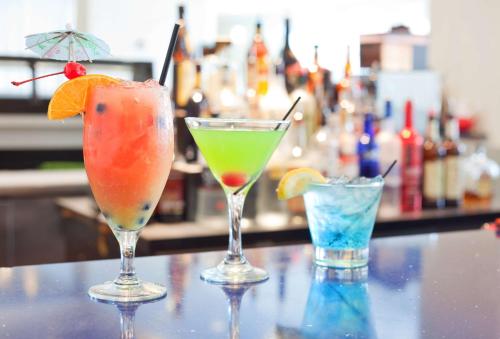 three cocktails sitting on top of a bar at Hilton Pensacola Beach in Pensacola Beach