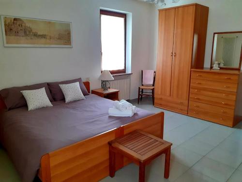 1 dormitorio con 1 cama grande y tocador de madera en La Rocconella, en Arten