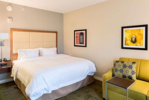 a hotel room with a bed and a chair at Hampton Inn & Suites New Albany Columbus in New Albany