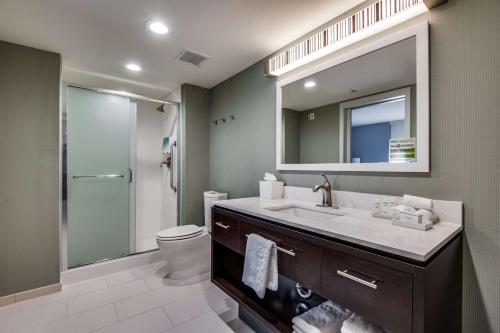 La salle de bains est pourvue d'un lavabo, de toilettes et d'un miroir. dans l'établissement Home2 Suites by Hilton DFW Airport South Irving, à Irving