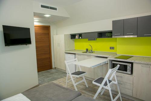 a kitchen with a table and chairs and a yellow wall at Arima city in Shumen