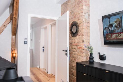a room with a brick wall and a white door at Triumph Ferienhäuser & Apartments in Rangsdorf