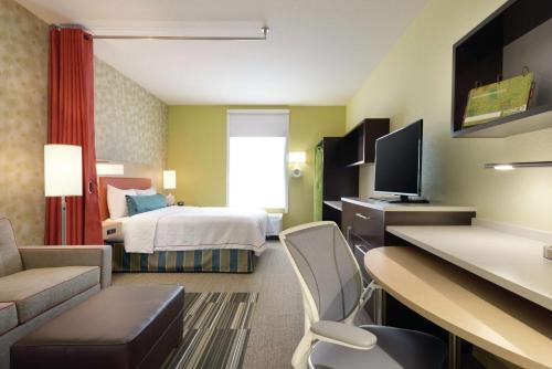 a hotel room with a bedroom with a bed and a desk at Home2 Suites by Hilton Cleveland Independence in Independence