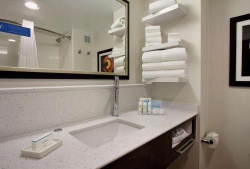 a bathroom with a sink and a mirror and towels at Hampton Inn Philadelphia-Great Valley in Frazer