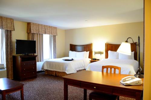 a hotel room with two beds and a table and a desk at Hampton Inn & Suites Red Bluff in Red Bluff