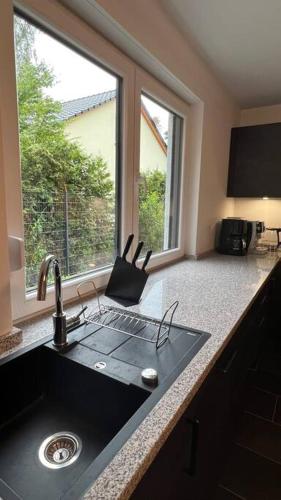 un bancone della cucina con lavandino e finestra di Modernes Apartment a Rangsdorf