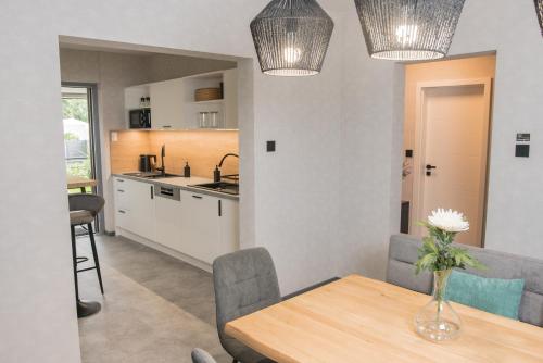 - une cuisine et une salle à manger avec une table et des chaises dans l'établissement Triumph Inn Ferienhaus, à Rangsdorf