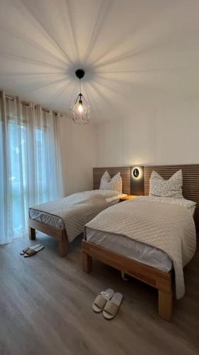 a bedroom with two beds and a chandelier at Modernes Apartment in Rangsdorf