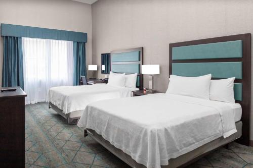 a hotel room with two beds and two windows at Homewood Suites by Hilton Phoenix Airport South in Phoenix