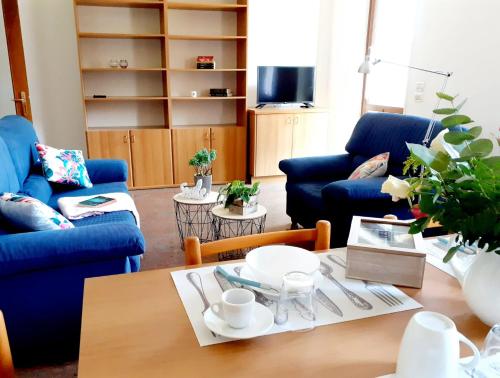 una sala de estar con sofás azules y una mesa. en La Rocconella, en Arten