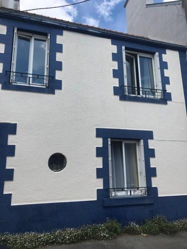 niebiesko-biały budynek z dwoma oknami w obiekcie Maison Lorient Sud w mieście Lorient
