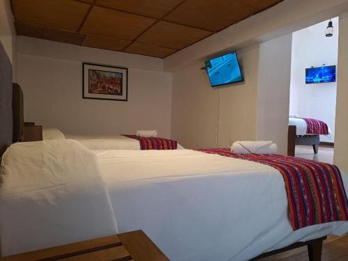 1 dormitorio con 2 camas blancas en una habitación en Marina's House Cusco Centro, en Cusco