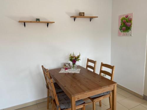 uma mesa de jantar com cadeiras e uma parede branca em Gemütliche Wohnung in Genthin OT Tucheim em Tucheim