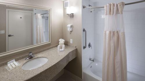 a bathroom with a sink and a shower curtain at Hilton Garden Inn Rockaway in Rockaway
