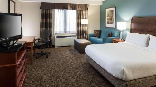a hotel room with a bed and a flat screen tv at Hilton Garden Inn Rockaway in Rockaway