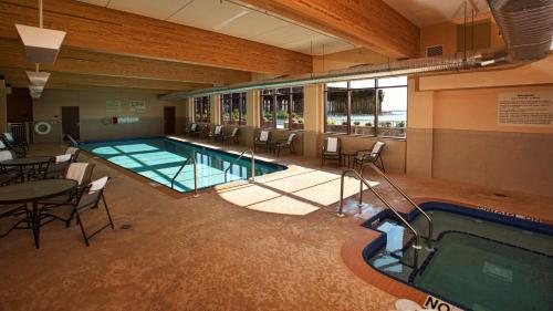a swimming pool with a table and chairs and a table and a tablektopktop at Hampton Inn Marquette-Waterfront in Marquette