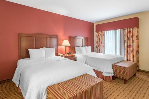 two beds in a hotel room with red walls at Hampton Inn & Suites Arcata in Arcata