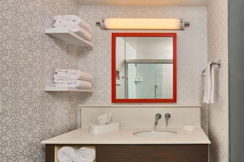 uma casa de banho com lavatório, espelho e toalhas em Hampton Inn Anchorage em Anchorage