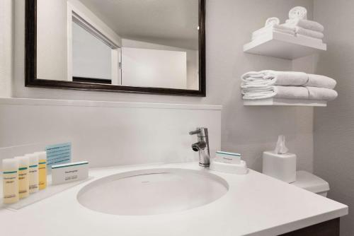 uma casa de banho com lavatório, espelho e toalhas em Hampton Inn Wausau em Wausau