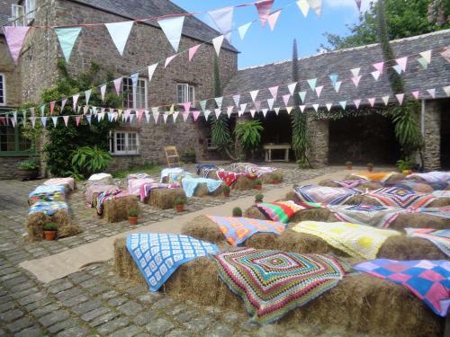 a group of hay bales with colorful blankets and flags at Ash Barton - Big Party House, No Curfew! in Wrafton