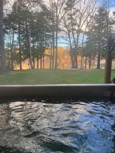 a pool of water with a view of a park at Lakeside Getaway with Hot Tub in Gaylord